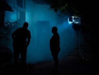Zwei Silhouetten stehen nachts im blauen Licht einer Filmszene