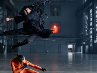 Zwei Darsteller führen in einer Halle eine dynamische Kampfszene aus