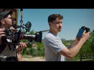 Filmteam dreht mit großer Kamera eine Szene in einer Weinlandschaft